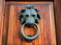 Bronze lionÃ¢â¬â¢s head with a ring door knocker on an old wooden door Royalty Free Stock Photo